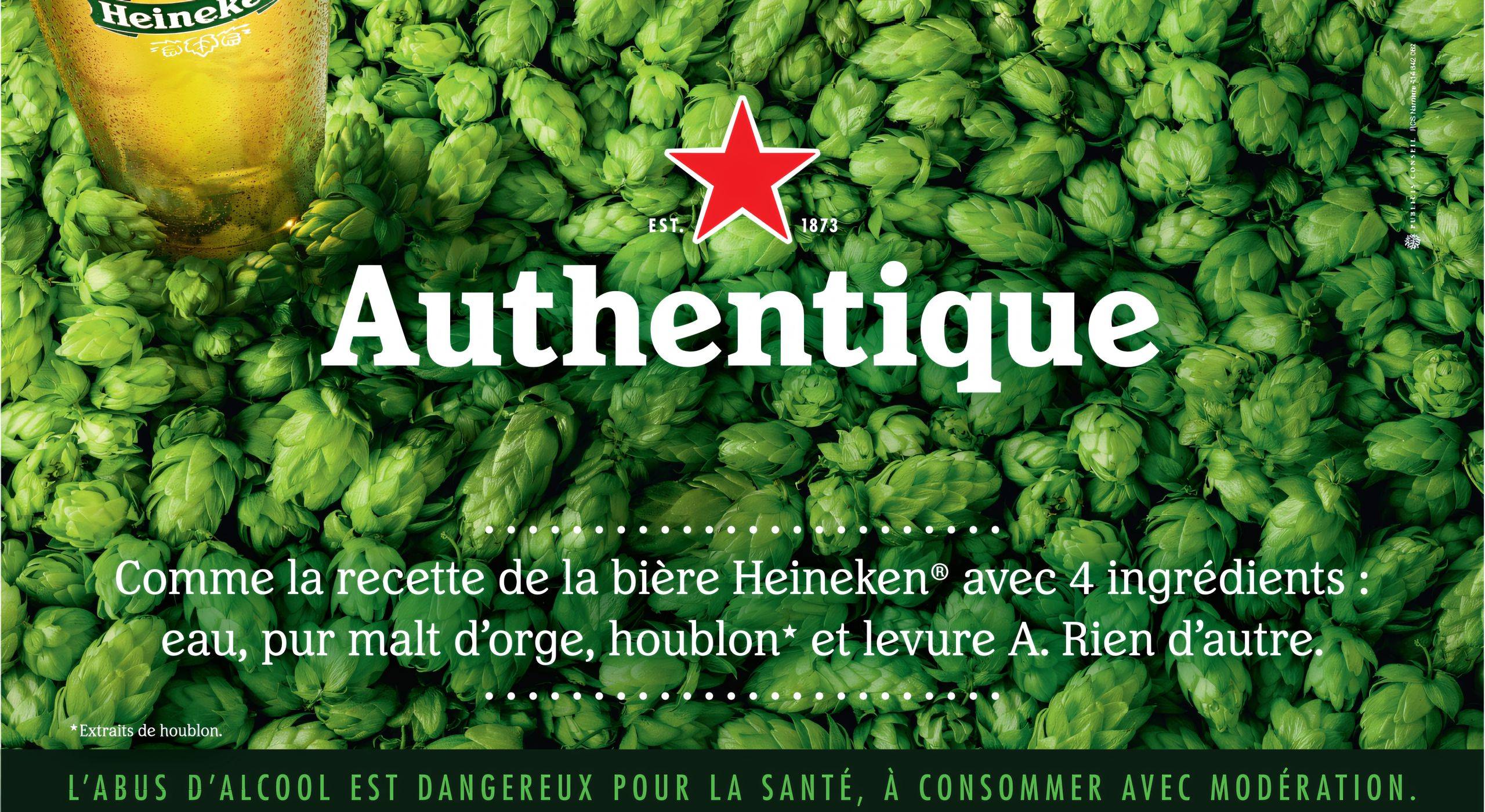 Affiche publicitaire de Heineken avec un verre de bière et un fond de houblon vert, mettant en avant la recette authentique avec quatre ingrédients : eau, pur malt d’orge, houblon et levure A.